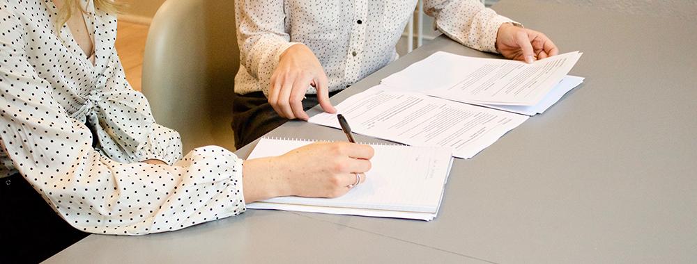 two women signing paperwork
