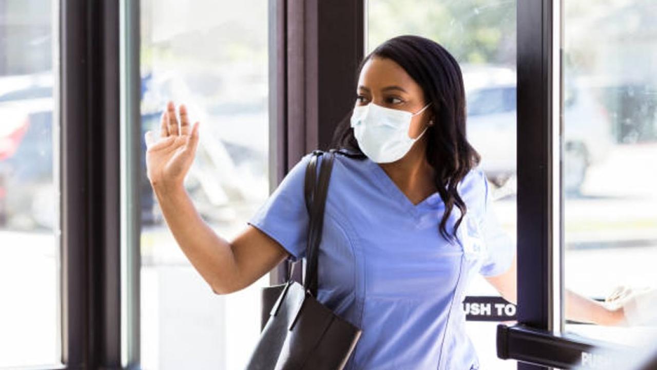 nurse waving goodbye as she exits door